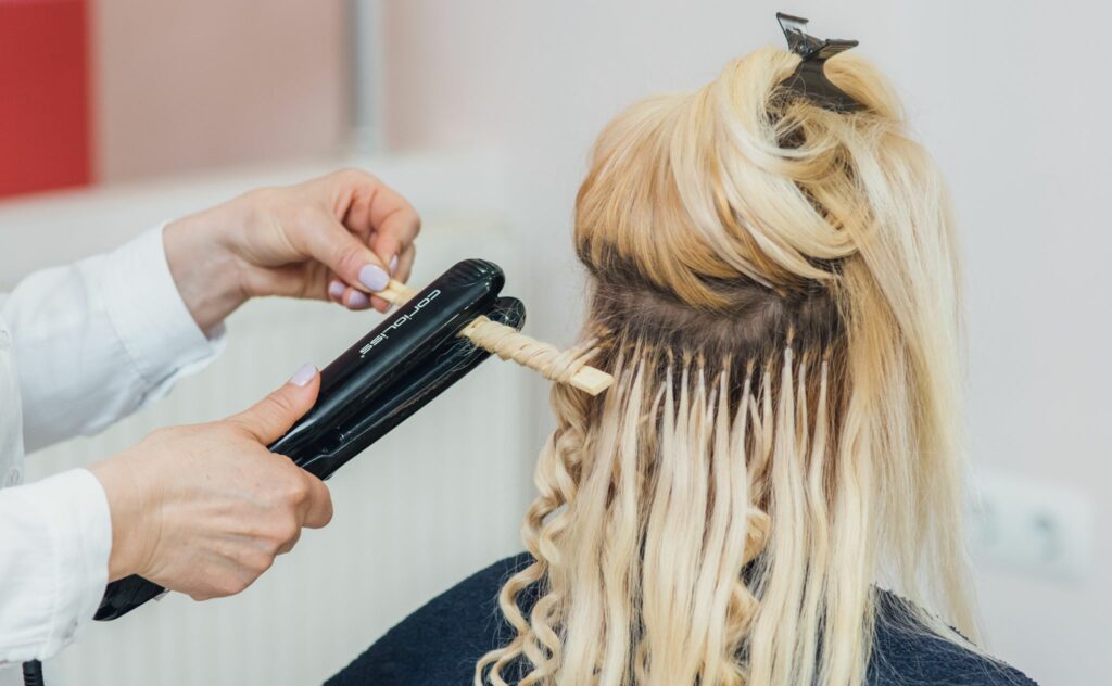 Hair extensions being applied in a salon.